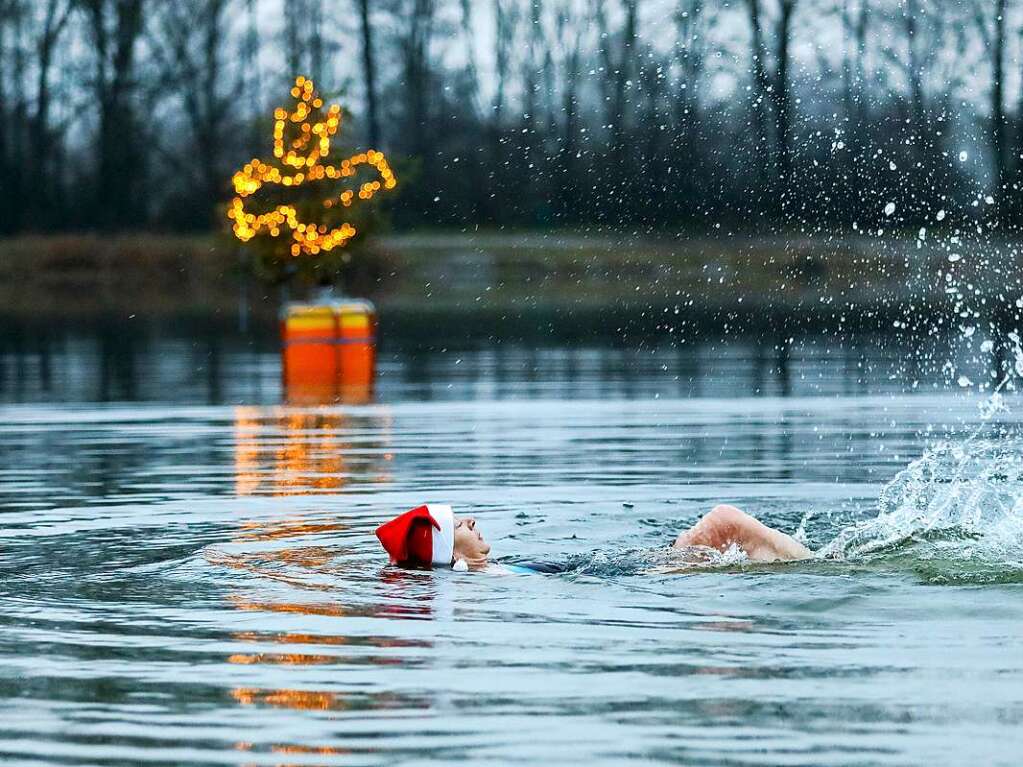 Eine Frau schwimmt kurz nach Tagesanbruch im Schwarzachtalsee in der Nhe von Biberach.