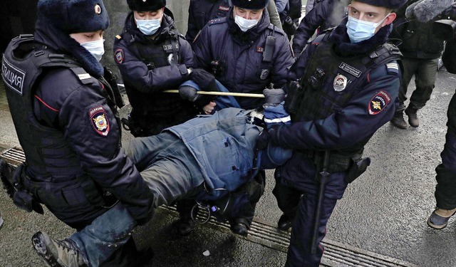 Polizisten tragen am Dienstag einen De...vor dem Gerichtsgebude in Moskau weg.  | Foto: Uncredited (dpa)