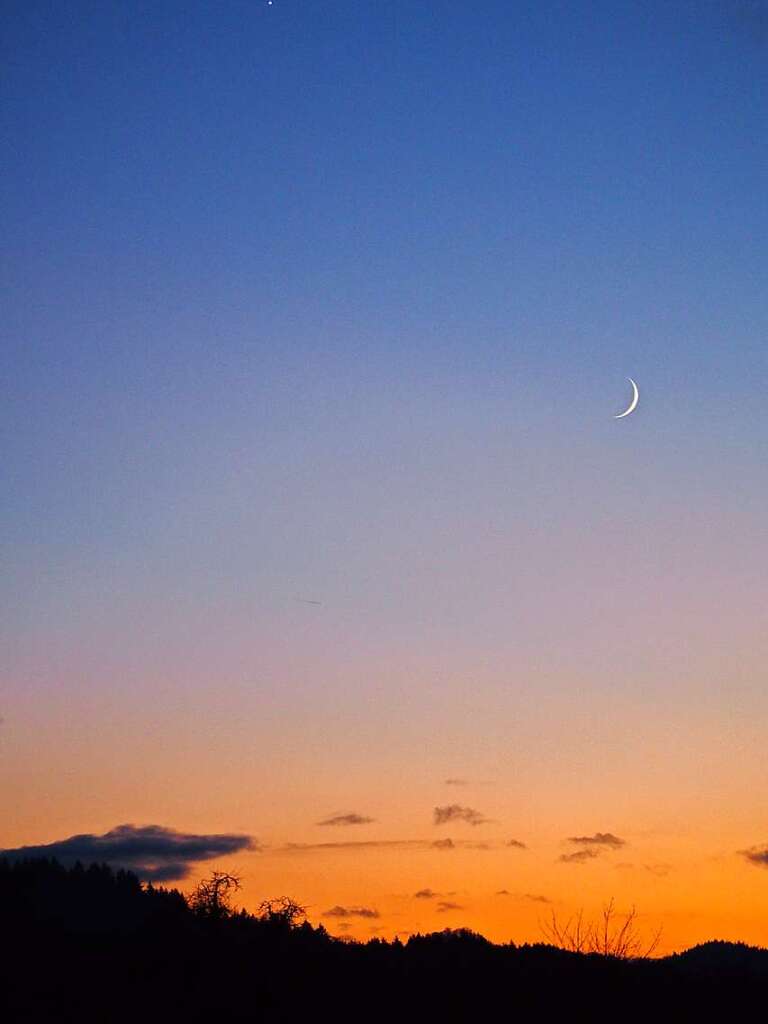 Ein farbenfroher Himmel begrt den nun wieder wachsenden Mond. Michael Wisser gelang dieses Motov.