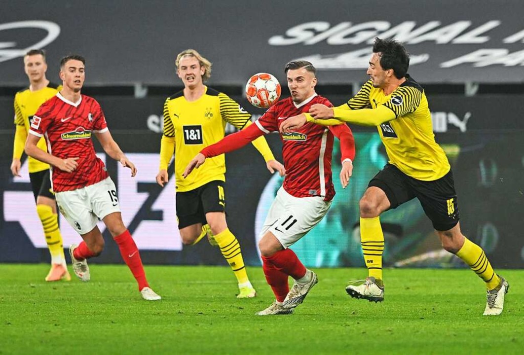 Dortmunds Mats Hummels (r) und Freiburgs Ermedin Demirovic in Aktion.  | Foto: David Inderlied (dpa)