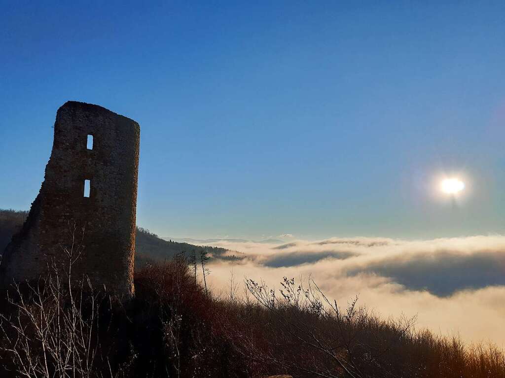 Die Ruine der Schneeburg in der Abendsonne ber dem Nebelmeer der Rheinebene.