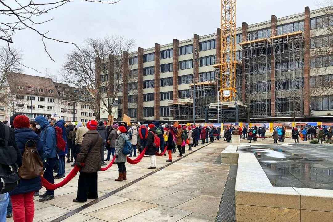 Der Gedenkbrunnen auf dem Platz wird von Ordnerinnen und Ordnern freigehalten.  | Foto: Anika Maldacker