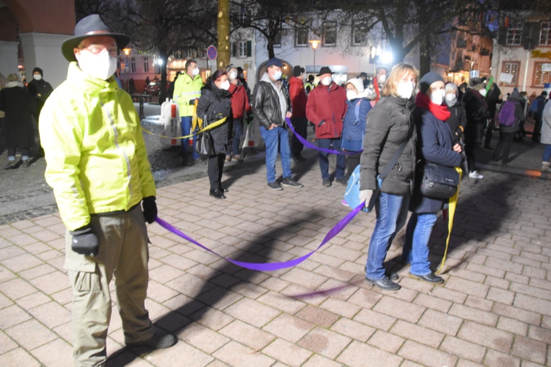 Demonstranten auf dem Marktplatz halten bunte Bänder.  | Foto: Nicolai Kapitz