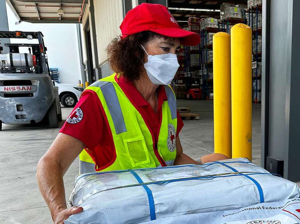 Australien: Eine Mitarbeiterin des Roten Kreuz beim Verladen von Hilfsgtern, fr betroffene Gemeinden nach dem Ausbruch des Untersee-Vulkans bei Tonga.