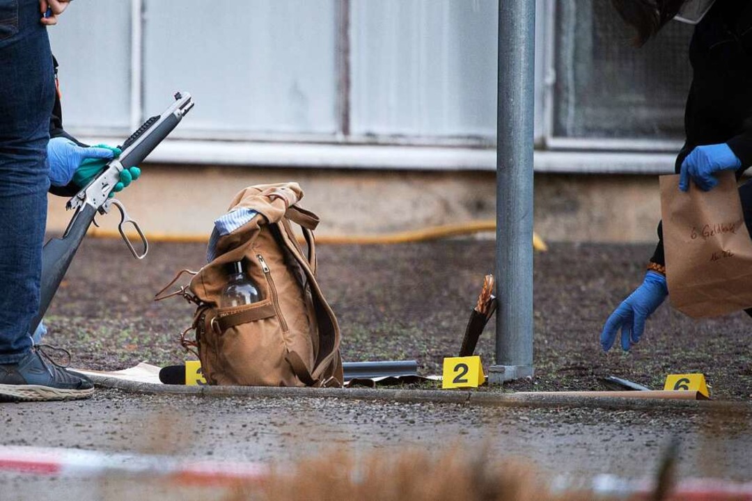 Polizeibeamte untersuchen eine Waffe u... Gelnde der Heidelberger Universitt.  | Foto: Sebastian Gollnow (dpa)
