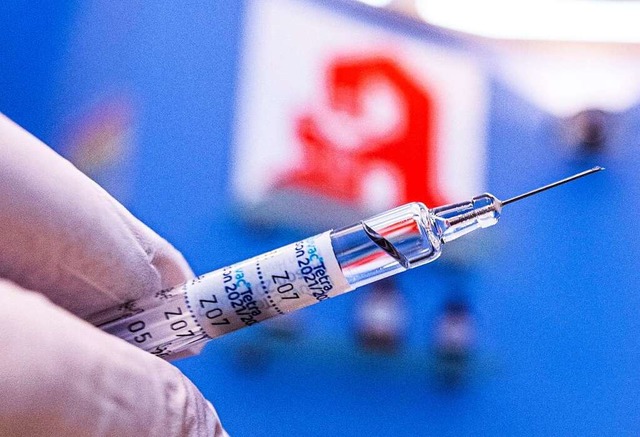 Ein Apotheker hlt eine Spritze mit Gr...nen und Apotheker gegen Corona impfen.  | Foto: David Inderlied (dpa)