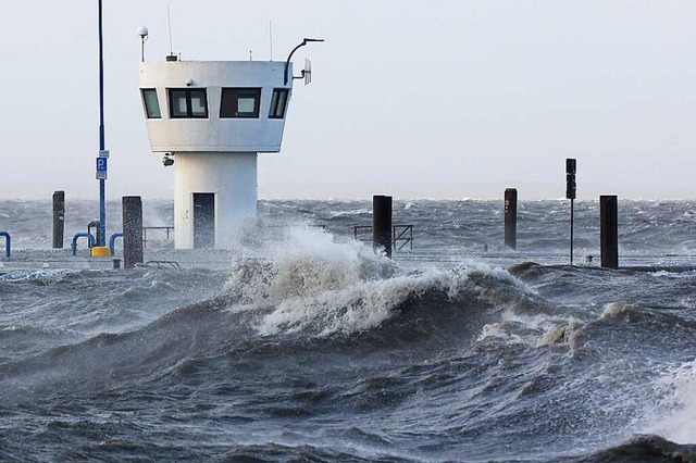 Wellen der aufgepeitschten Nordsee dr...ei Sturm auf den Fhranleger Dagebll.  | Foto: Bodo Marks (dpa)