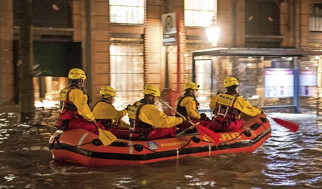 Mitglieder der DLRG in einem Schlauchboot am Hamburger Fischmarkt  | Foto: Daniel Bockwoldt (dpa)