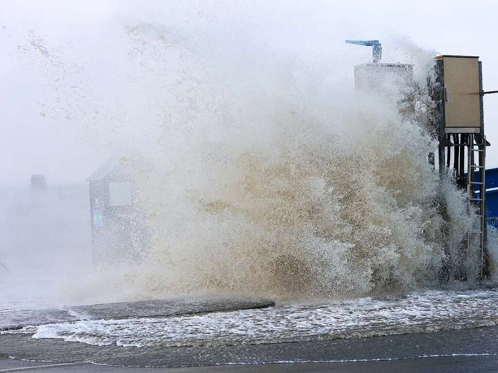 Die Gischt der aufgepeitschten Nordsee berflutet bei Sturm den Fhranleger Dagebll.