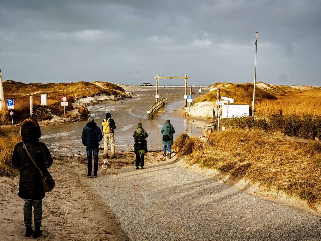 Spaziergnger versuchen die berfluteten Wanderwege zwischen den Dnen zu passieren.