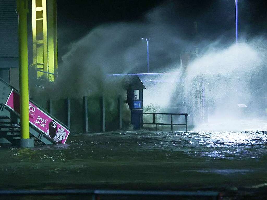 Die Gischt der aufgepeitschten Nordsee berflutet bei Sturm den Fhranleger Dagebll.