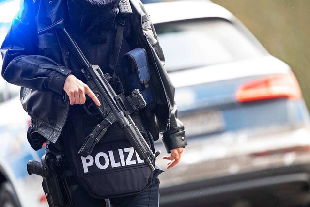 Polizeibeamte stehen an einer Absperru...nen Kilometer von dem Tatort entfernt.  | Foto: Sebastian Gollnow (dpa)