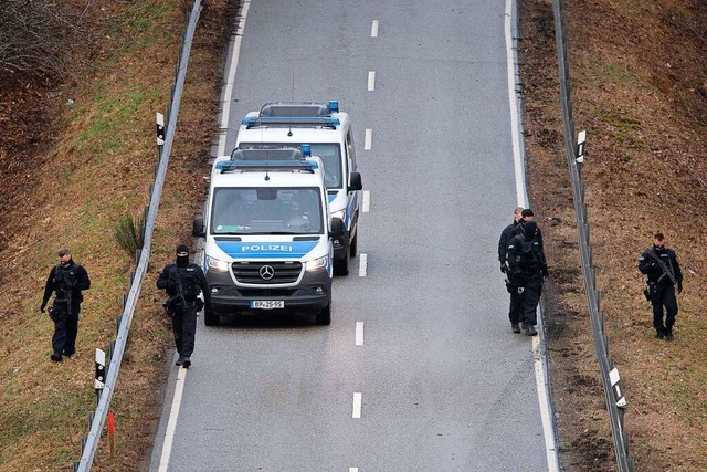 Polizeibeamte suchen nach den tdliche...ter vom Tatort entfernt die Strae ab.  | Foto: Sebastian Gollnow (dpa)