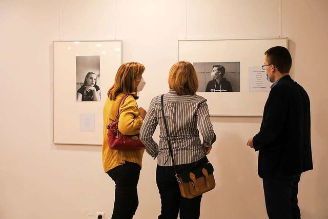 Besucherinnen und Besucher betrachten die Bilder und Texte.  | Foto: Christoph Breithaupt