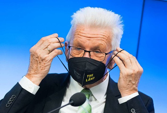 Maske mit &quot;The Lnd&quot;-Schrift...setzt sich nach einer Pressekonferenz.  | Foto: Bernd Weibrod (dpa)