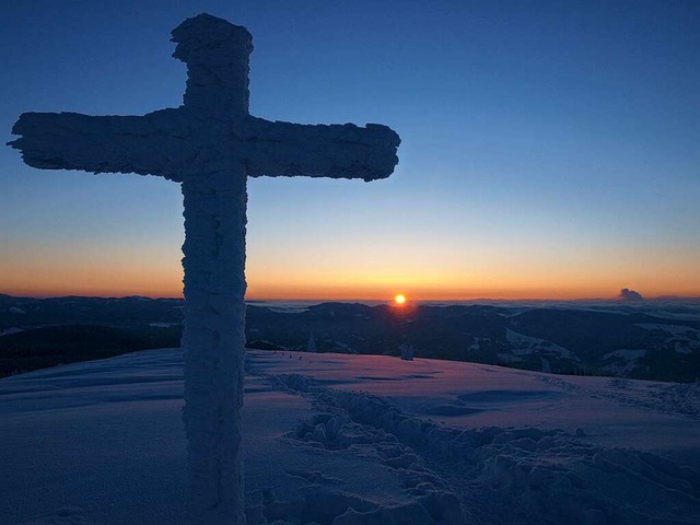 Spektakel: Das Gipfelkreuz des Belchen... Im Hintergrund lugt die Sonne hervor.  | Foto: Doris Burger