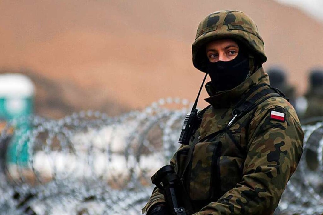 Ein bewaffneter Grenzsoldaten bewachet die Grenze zu Belarus.  | Foto: Attila Husejnow (dpa)