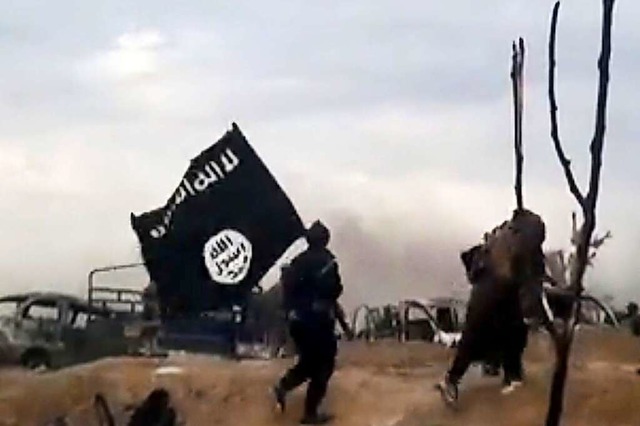IS-Kmpfer laufen mit einer IS-Flagge....rmiliz Islamischer Staat (IS) gettet.  | Foto: Uncredited (dpa)