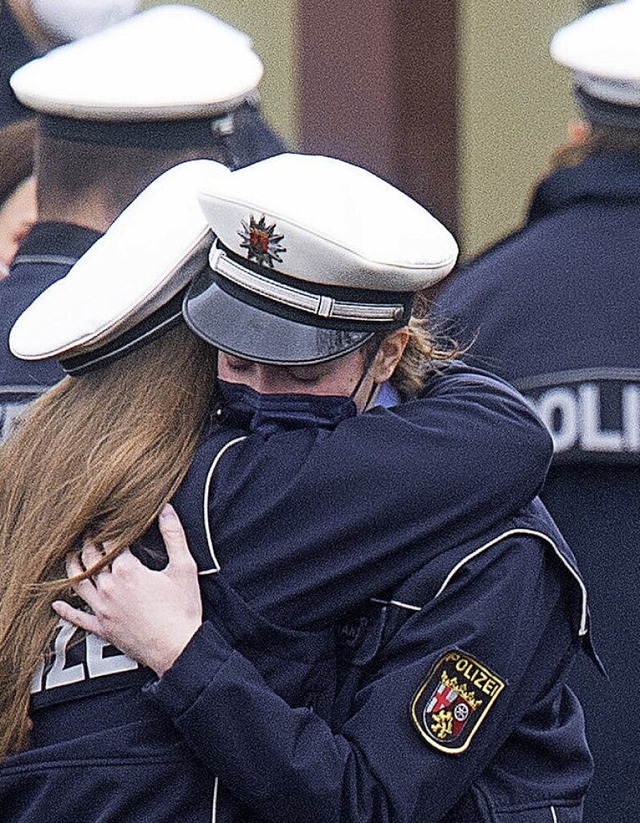 Zwei Polizeibeamtinnen umarmen sich nach der Gedenkfeier in Kusel.  | Foto: Sebastian Gollnow (dpa)
