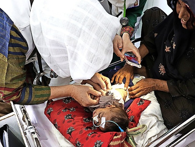 Ein Kinderarzt und eine Krankenschwest... leidet, im Licht eines Mobiltelefons.  | Foto: Elise Moulin