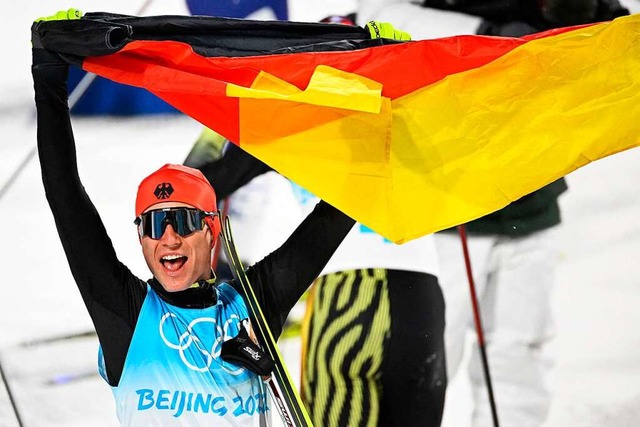 Vinzenz Geiger jubelt mit der Fahne.  | Foto: TOBIAS SCHWARZ (AFP)