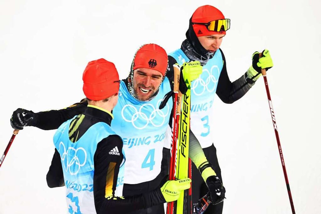 Johannes Rydzek (Mitte) gratulierte fa...er nach dem Springen noch Dritter war.  | Foto: Daniel Karmann (dpa)