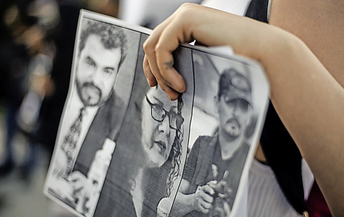 Ein Demonstrant zeigt die Fotos von ermordeten Journalisten.  | Foto: Cesar Gomez via www.imago-images.de