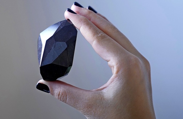 Eine Mitarbeiterin von Sotheby&#8217;s... den schwarzen Diamanten in der Hand.   | Foto: Kamran Jebreili (dpa)