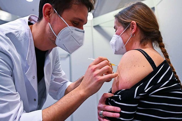 Christopher Riffel (l) vom Klinikum St...on in Stuttgart gegen das Coronavirus.  | Foto: Bernd Weibrod (dpa)