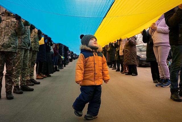 Ein Kind luft am &#8222;Tag der Einhe... in Kiew unter eine Fahne der Ukraine.  | Foto: Vadim Ghirda (dpa)