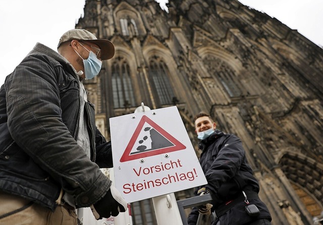Mitarbeiter des Klner Domes haben War...vor herabfallenden Steinen  zu warnen.  | Foto: Oliver Berg (dpa)