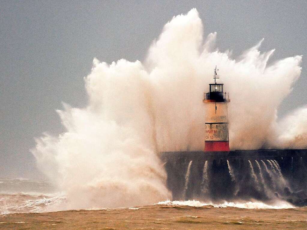 Wellen krachen an den Leuchtturm in Newhaven.