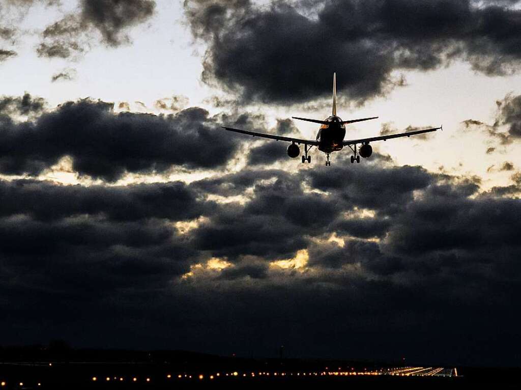 Ein Flugzeug landet whrend Orkantief Zeynep vor bedrohlicher Wolkenkulisse am Flughafen Hannover.