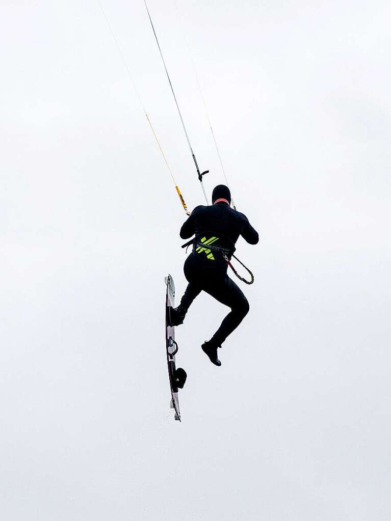 Ein Kitesurfer springt bei strmischem Wetter ber die Wellen der Nordsee bei Schillig.