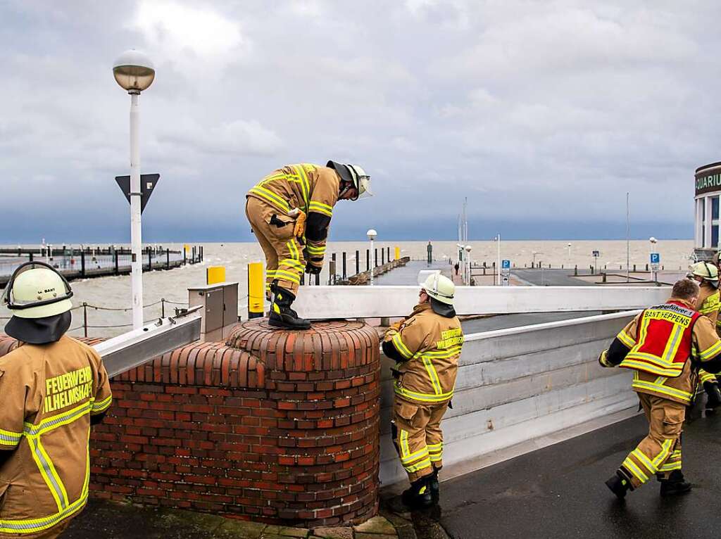 Einsatzkrfte der Feuerwehr in Wilhelmshaven schlieen in Vorbereitung auf die Sturmflut den Deichschart zum Helgolandkai.