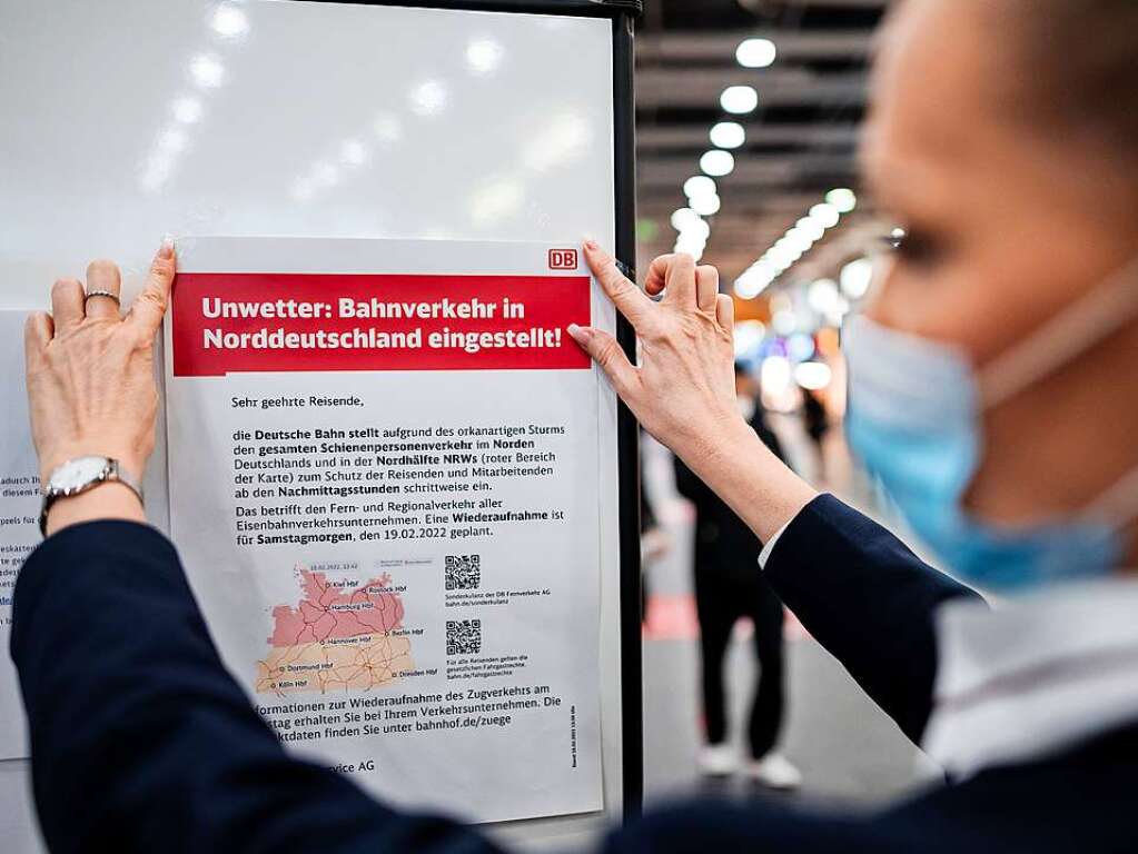 Eine Mitarbeiterin der Bahn hngt im Bahnhof von Essen einen Zettel auf, auf dem auf die Einstellung des Bahnverkehr in Teilen von Nordrhein-Westfalen hingewiesen wird.