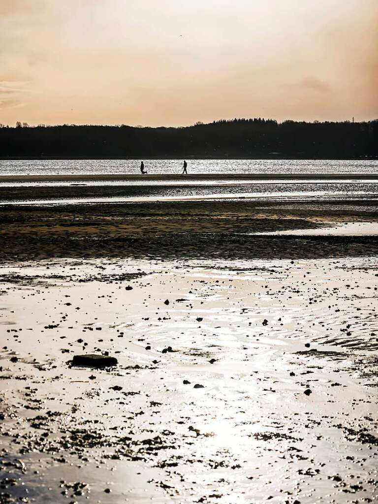 Nach dem schweren Sturm Zeynep in Teilen Deutschlands sind Spaziergnger bei Niedrigwasser und Sonnenschein am Falkensteiner Strand unterwegs.