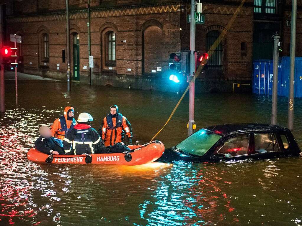 Feuerwehrleute retten in der Speicherstadt, whrend einer Sturmflut beim Hochwasser der Elbe, einen Mann aus seinem Auto, der zuvor versehentlich in das Wasser gefahren war.