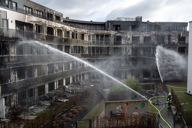 Die Feuerwehr lscht weiterhin einen a...orgen ein ganzer Wohnblock in Flammen.  | Foto: Bernd Thissen (dpa)