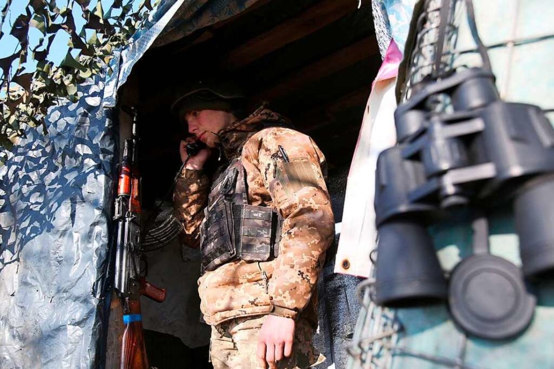 Ein ukrainischer Soldat erhält in der ...he Doneszk Informationen per Telefon.   | Foto: ANATOLII STEPANOV (AFP)