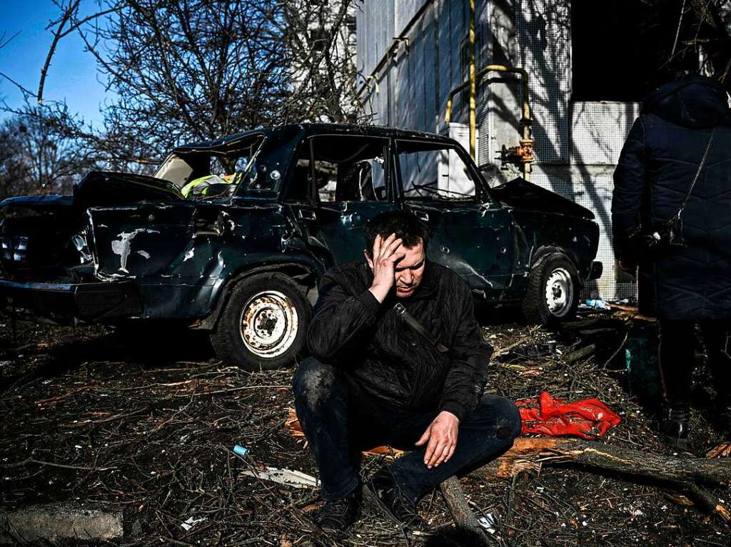 Ein Mann sitzt vor seinem zerstrten Gebude nach Bombenanschlgen auf die ostukrainische Stadt Tschuhujiw