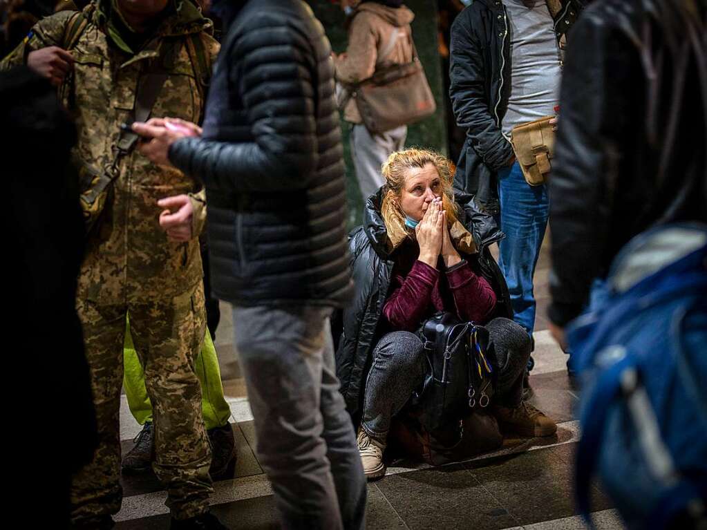 Kiew: Eine Frau sitzt auf ihrem Gepck, whrend sie am Bahnhof darauf wartet die Stadt verlassen zu knnen.