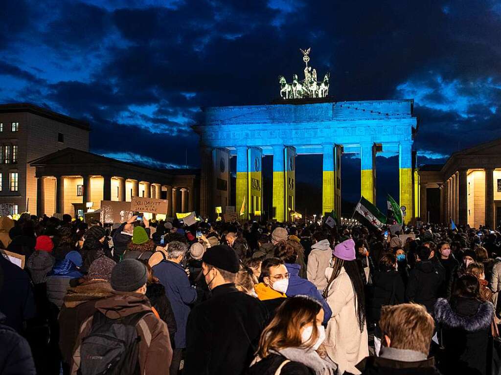 Das Brandenburger Tor wird am Abend bei einer Solidaritts-Demonstration fr die Ukraine, nach dem russischen Einmarsch in das Land, in den Farben der Ukraine angeleuchtet.