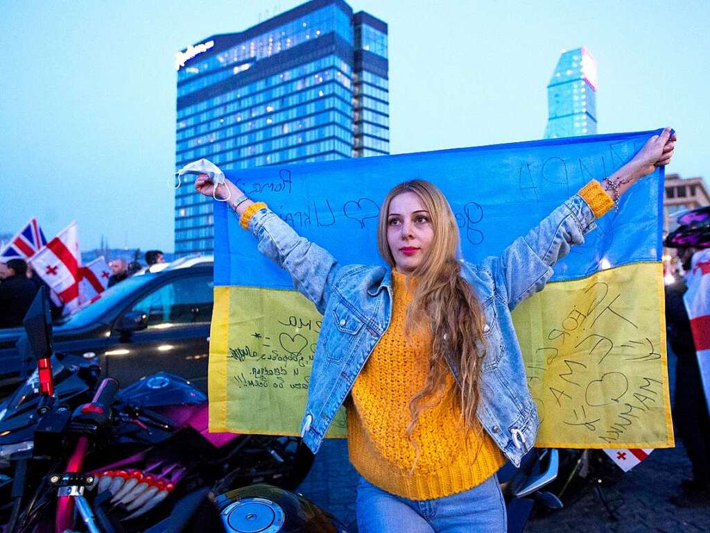 Eine Frau hlt eine ukrainische Flagge bei einer Demonstration zur Untersttzung der Ukraine in Tiflis, Georgien.