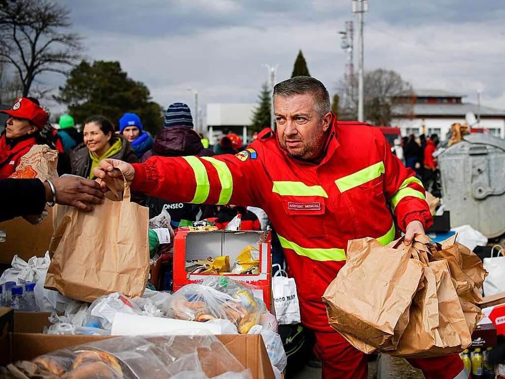 Rumnien: Ein Mitarbeiter des Mobilen Rettungsdienstes verteilt an der rumnisch-ukrainischen Grenze Taschen mit Lebensmitteln an Flchtlinge.