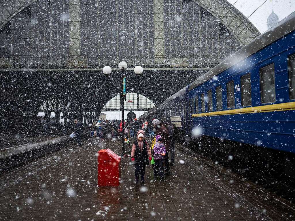 Lwiw: Eine ukrainische Familie steht whrend es schneit auf dem Bahnsteig.