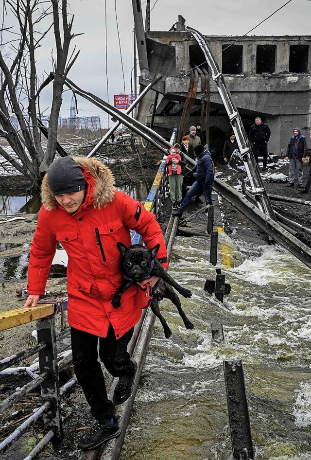 In Kiew berqueren Menschen eine zerstrte Brcke.  | Foto: ARIS MESSINIS (AFP)