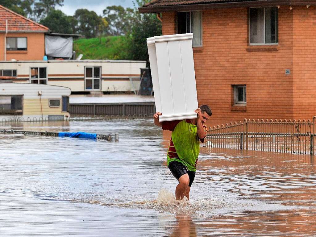 Ein Mann im Westen von Sydney bringt Mbel aus seinem berfluteten Zuhause an einen sichereren Ort.