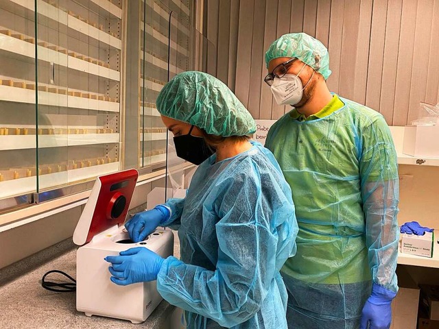 Corinna Wolf und Beat Winterhalder beim Befllen der neuen PCR-Testmaschine  | Foto: Tanja Bury
