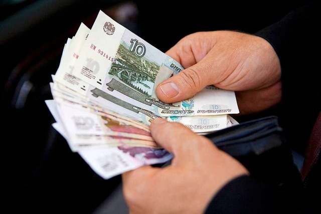 Ein Mann zhlt russische Rubel-Geldsch...rieg gegen die Ukraine zu finanzieren.  | Foto: Arno Burgi (dpa)